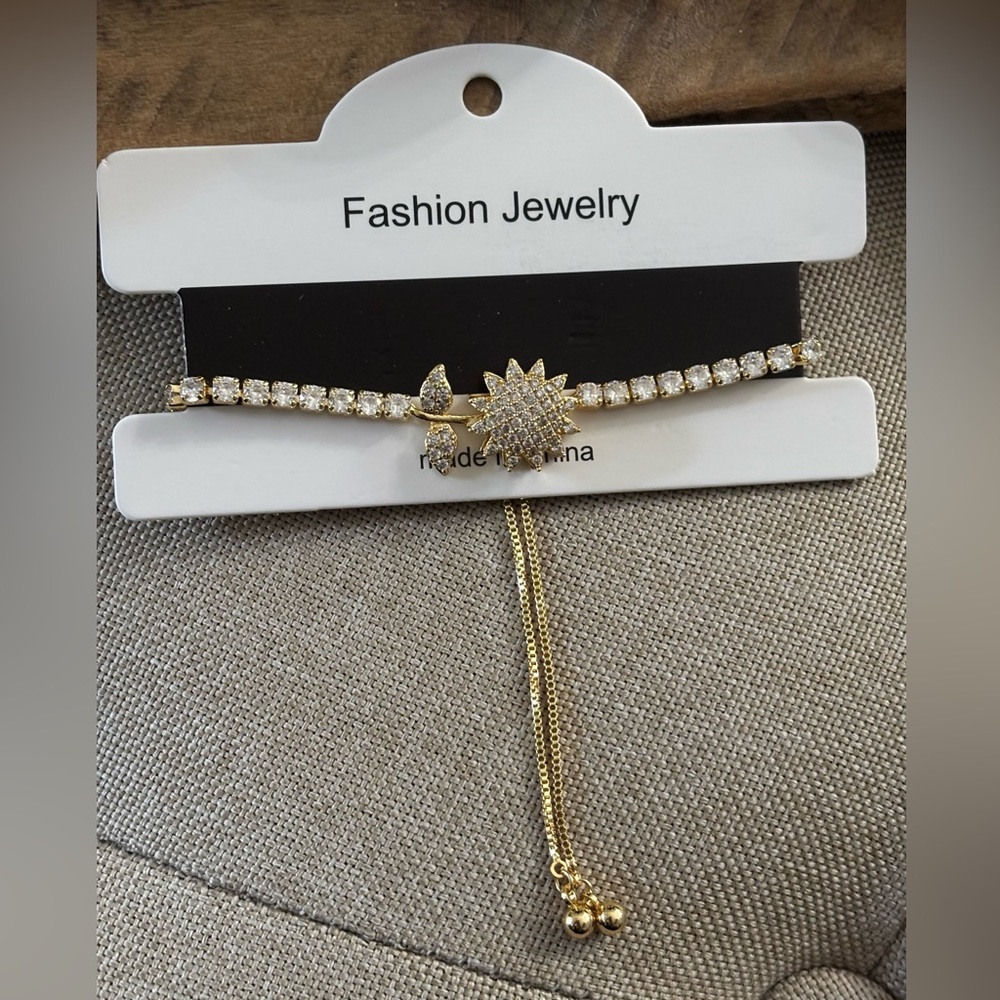 Gold tone rhinestone adjustable bracelet. Beautiful flower on top spins. NWT